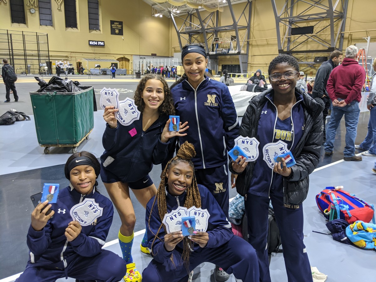 Athletes pose with their medals and patches.