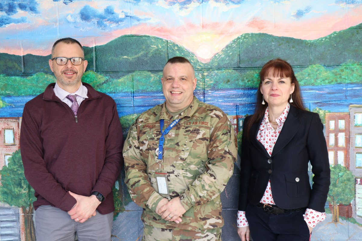 Mr. John Etri, Master Sergeant Granda, and Mrs. Elizabeth Thomas-Cappello pose for a photo.